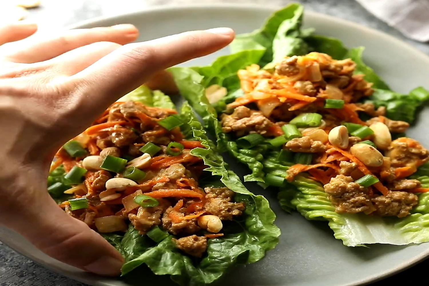 A hand holding a Thai turkey lettuce wrap. 