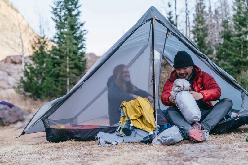 A man and a woman camping on a Gossamer Gear The Two tent.