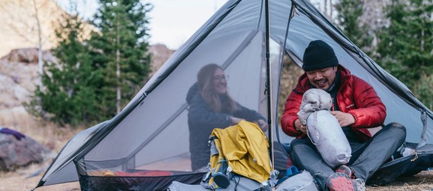 A man and a woman camping on a Gossamer Gear The Two tent.