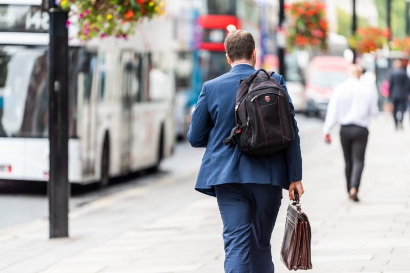 A businessman with backpack and briefcase.