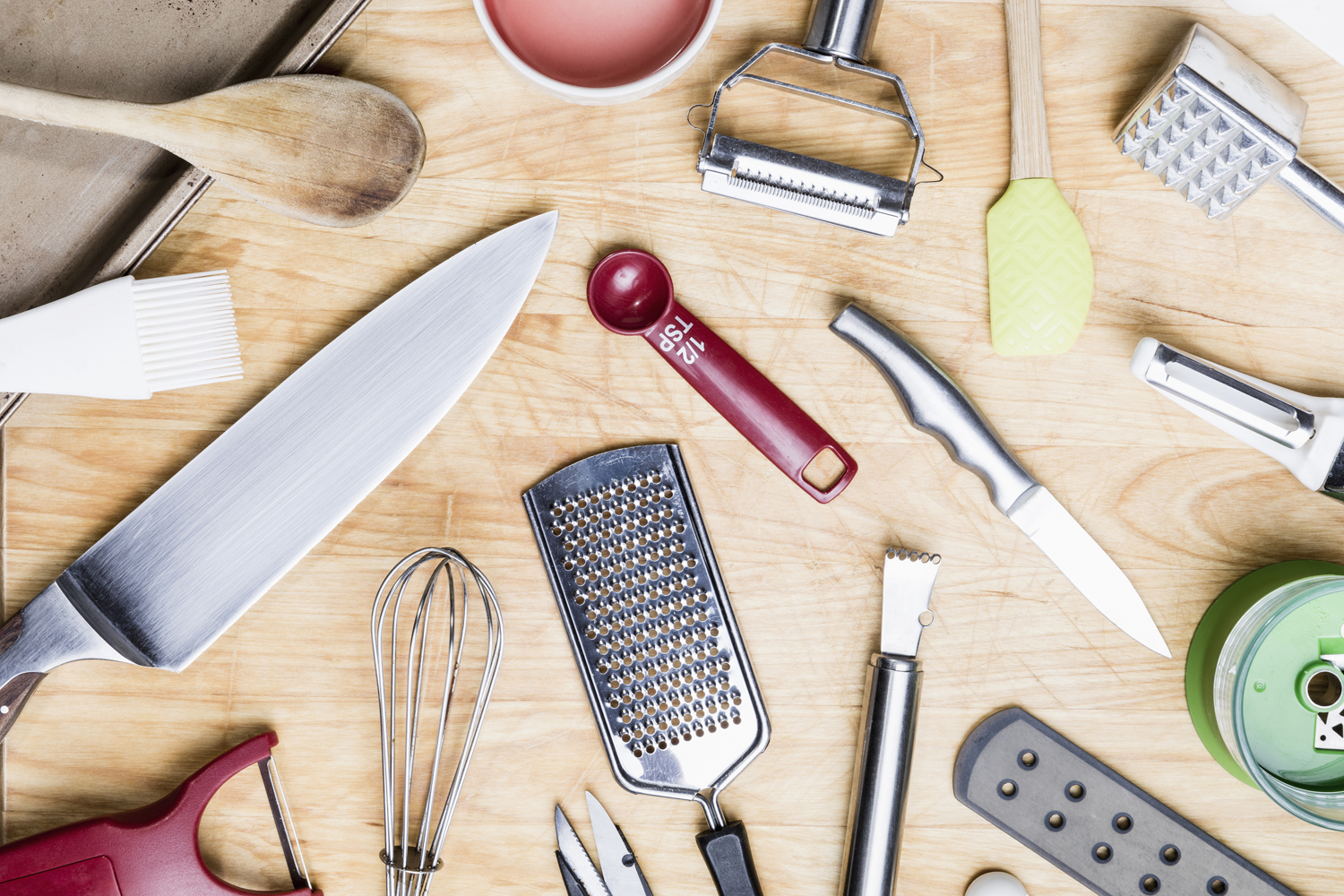 Assorted kitchen utensils on a wooden table.