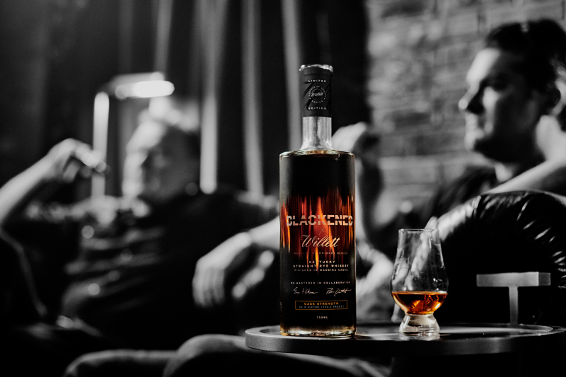 Blackened's Rob Dietrich (left) and Willett Distillery's Drew Kulsveen relax behind a bottle of the pair's new rye whiskey.