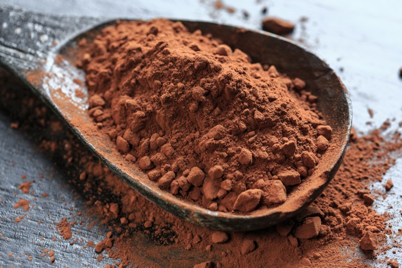 Un primer plano de cacao en polvo en cuchara.