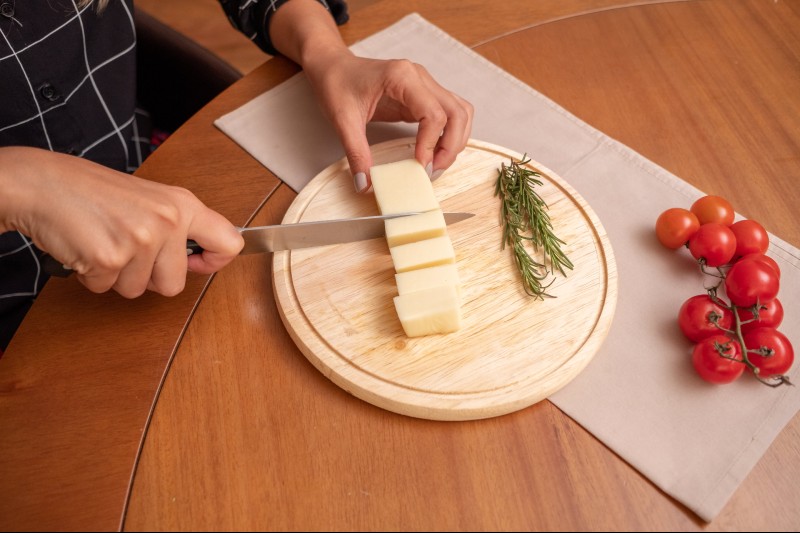 hands cutting butter on a cutting board.