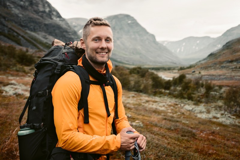 A smiling man carrying a backpack.