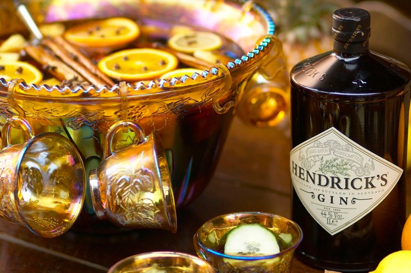 A bowl of Hendrick's hot gin punch beside a bottle of Hendrick's gin.