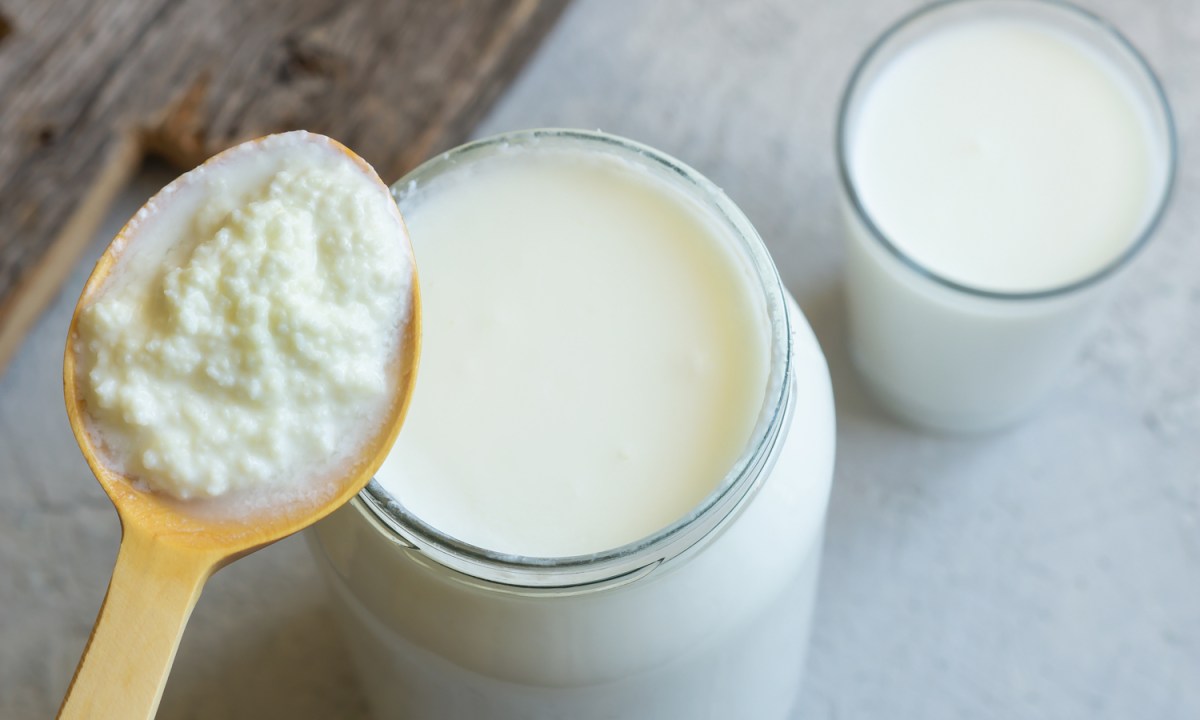 A spoonful of kefir and two glasses of kefir on a table