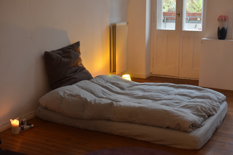 Old lumpy mattress sitting on the floor.