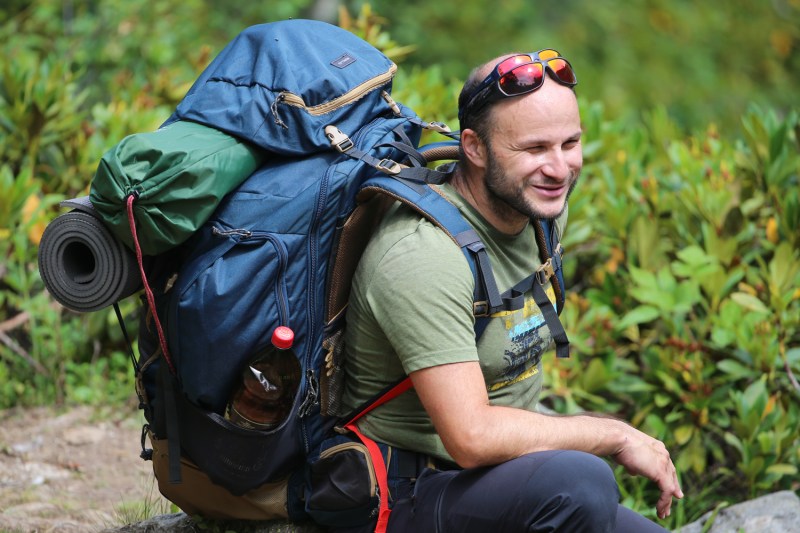 A hiker carrying his hiking pack and gear.