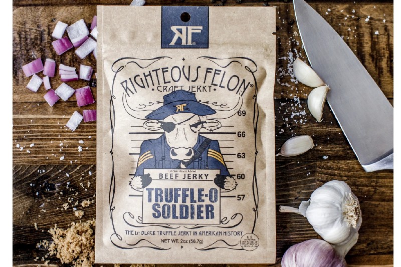 Righteous felon jerky bag on cutting board with knife.