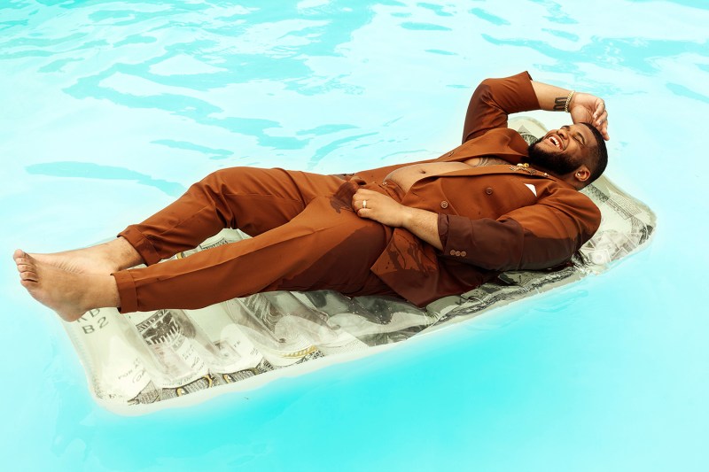 Model and photographer Steven Green floats in a swimming pool in a suit.