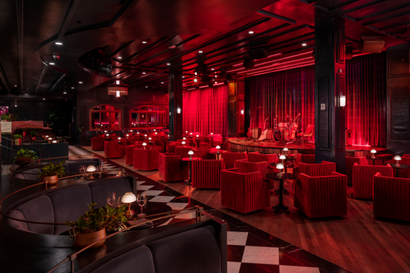 Dining tables and plush seats face The Twelve Thirty Supper Club's central stage.