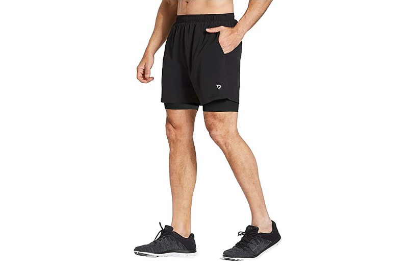 A midsection of a male model wearing a black running shorts from Baleaf.