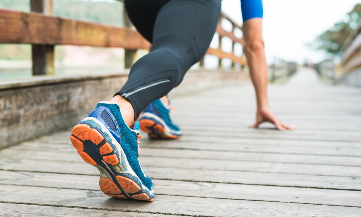 Fitness man ready for running on wooden walkway on park.