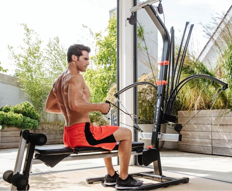 Man using the Bowflex Home Gym in an outdoor enclosed patio area.