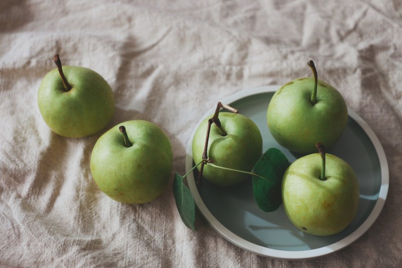Granny Smith apples in a bowl on a table. 