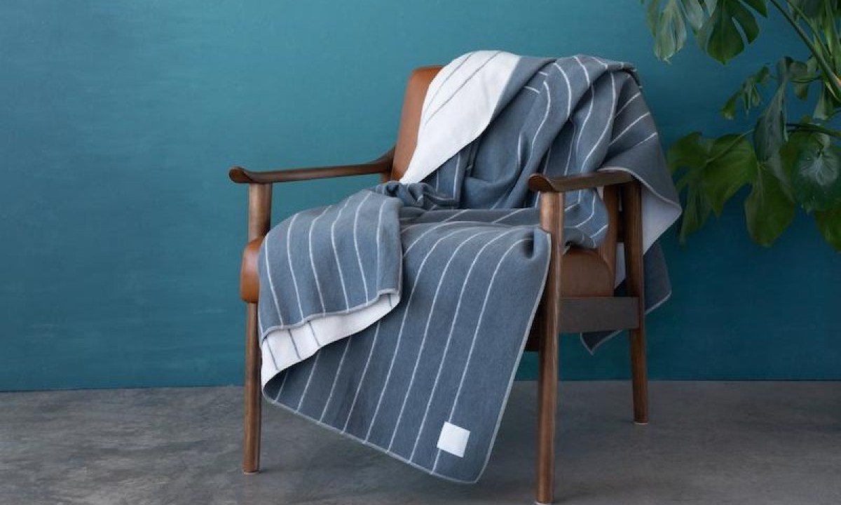 Rumpl's Merino SoftWool Blanket draped over a chair.