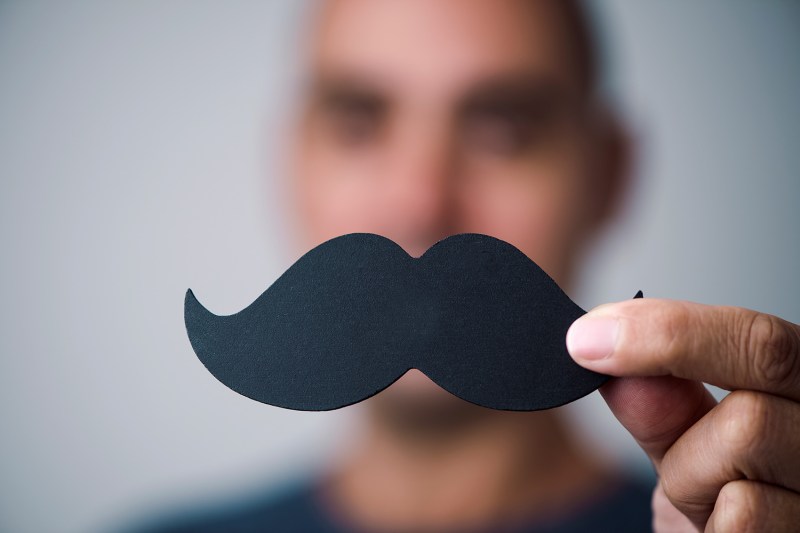 Young man with a fake moustache.