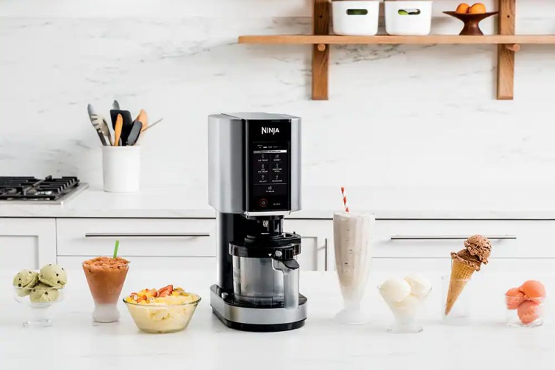 Ninja Creami Ice Cream Maker sitting on a counter with bowls of ice cream.