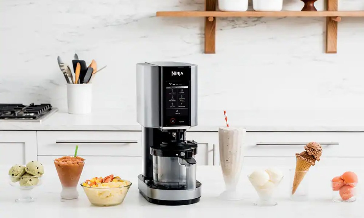 Ninja Creami Ice Cream Maker sitting on a counter with bowls of ice cream.