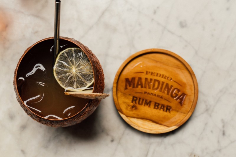 spice rum drink with Mandinga rum bar wooden coaster.