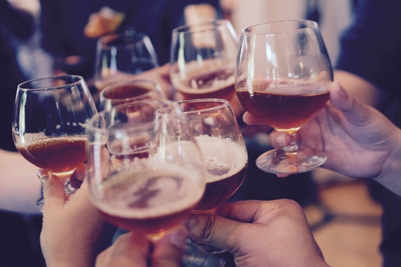 hands holding tulip beer glasses offering a cheers.