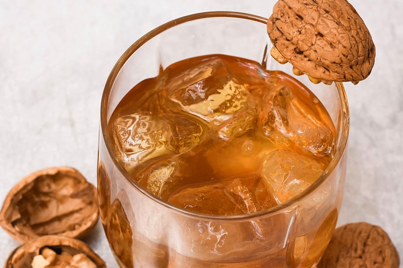 Een glas Walnut and Maple Old Fashioned naast walnoten.