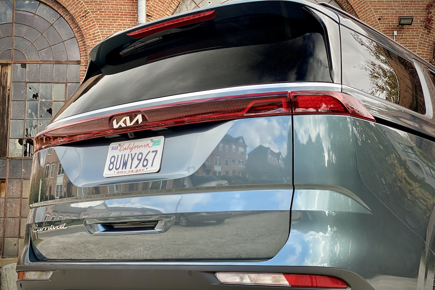 Kia Carnival close up of rear end angle from passenger side.