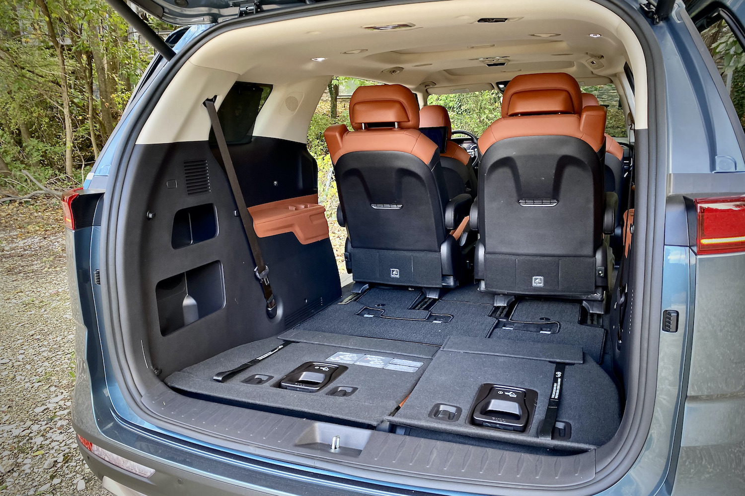 Kia Carnival cargo area with third-row seats stowed and liftgate open.
