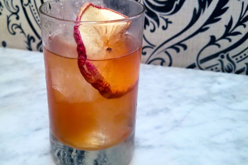 A glass of Almost Lost Lake with garnish on a table.