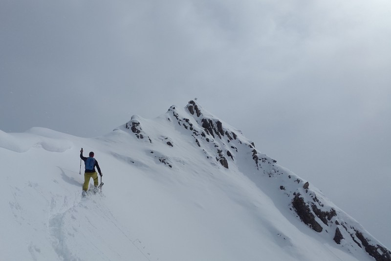 man backcountry skiing on a mountainside.