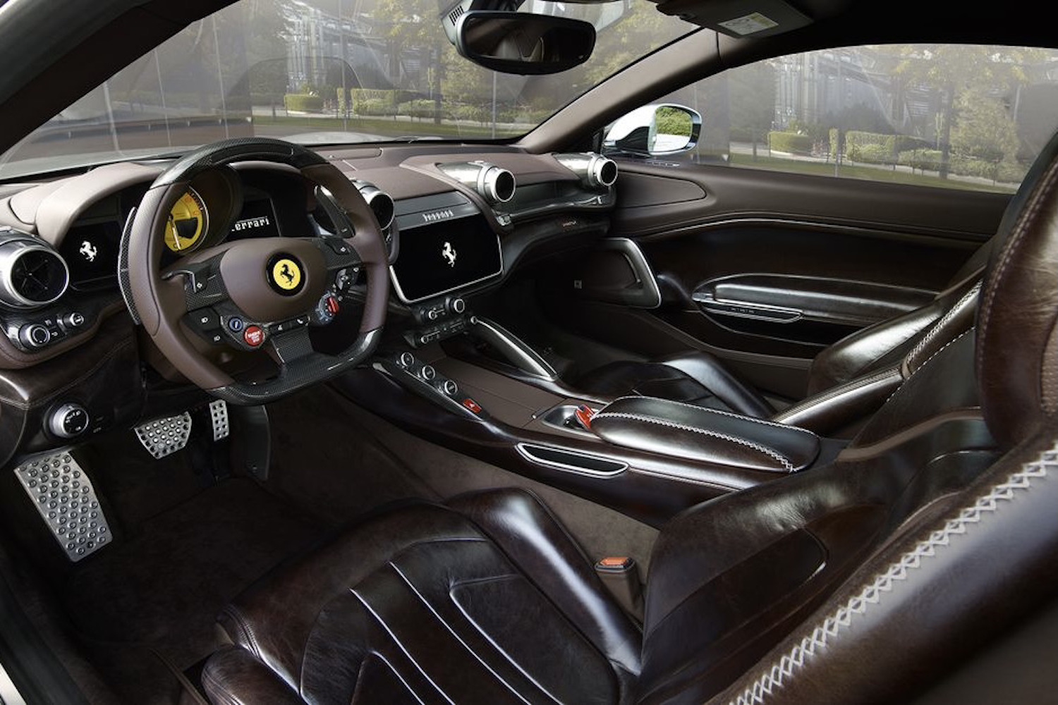 Ferrari BR20 interior from driver's side with seat and steering wheel.