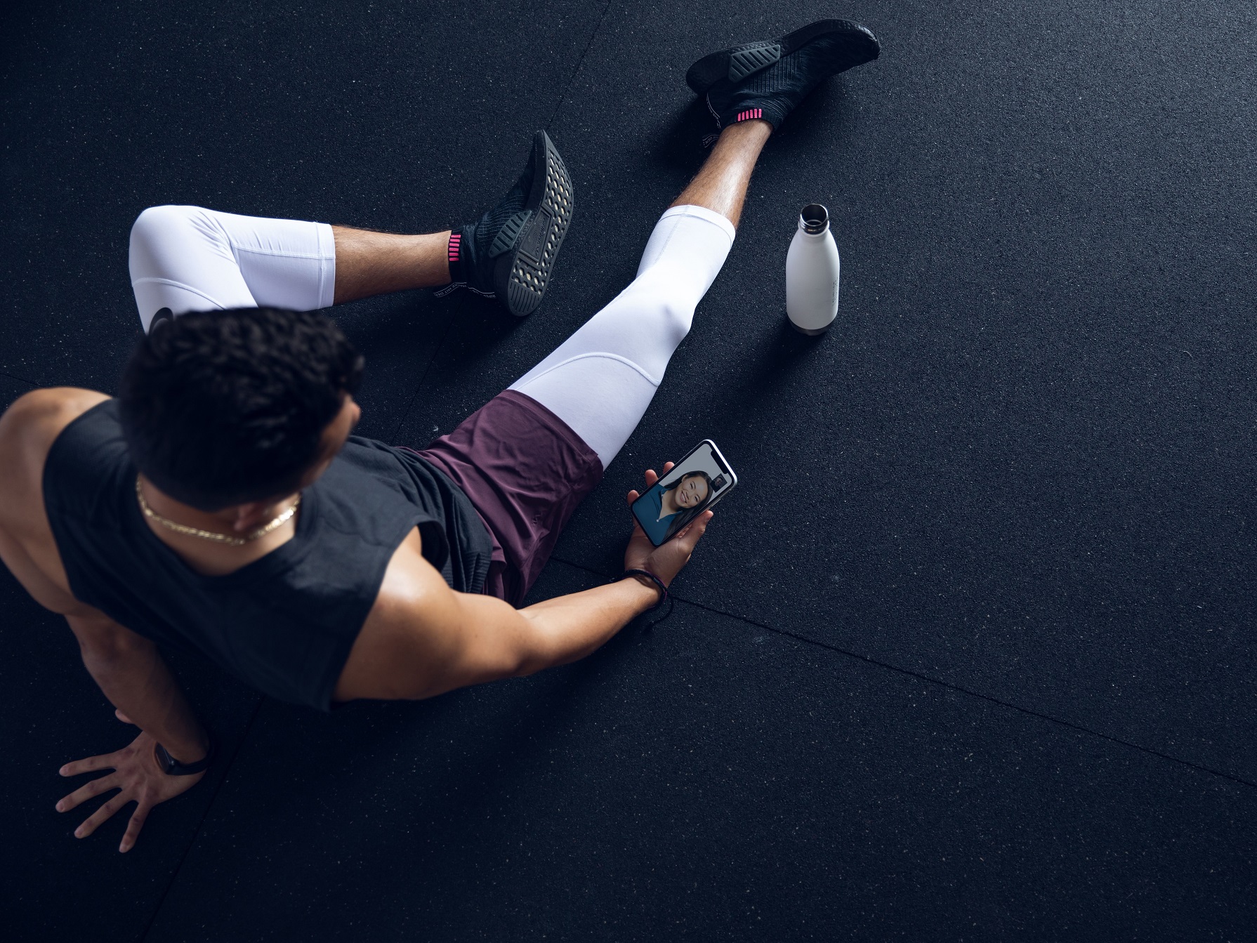 Future virtual personal trainer service used on mobile with bottle nearby.
