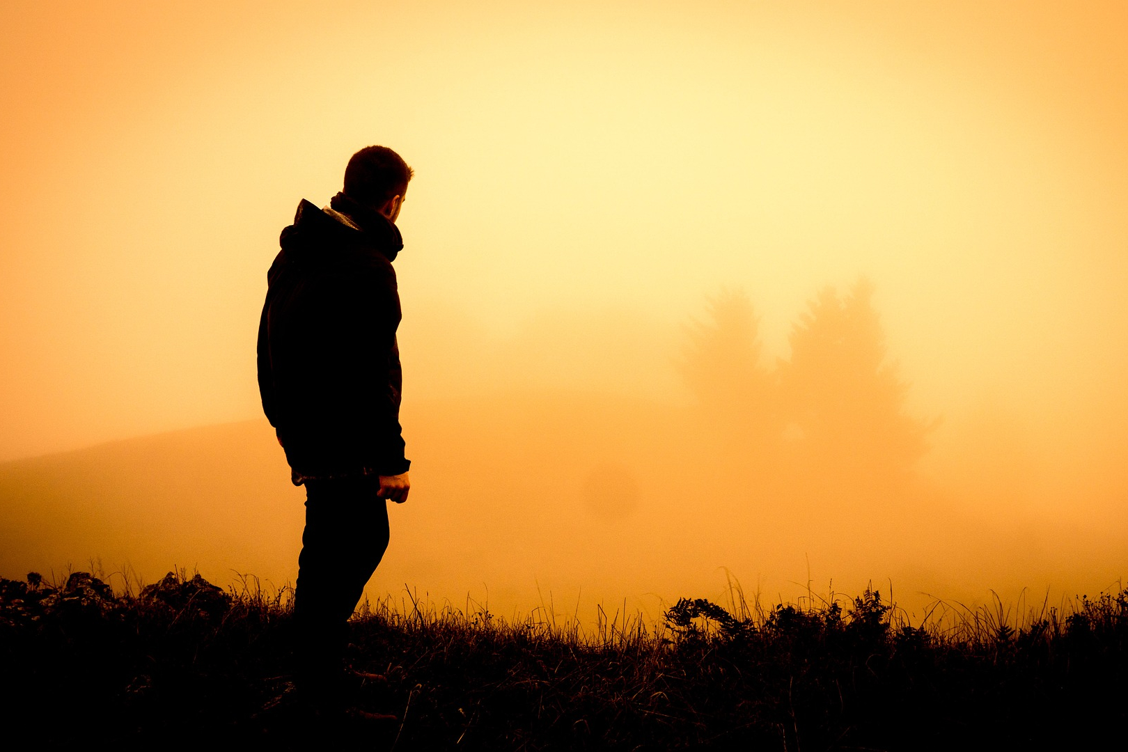 The silhouette of a hiker watching the sunrise.