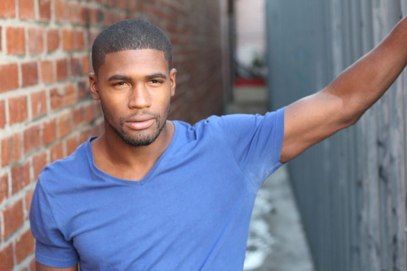 Man with deodorant stains on the armpit area of his blue shirt.