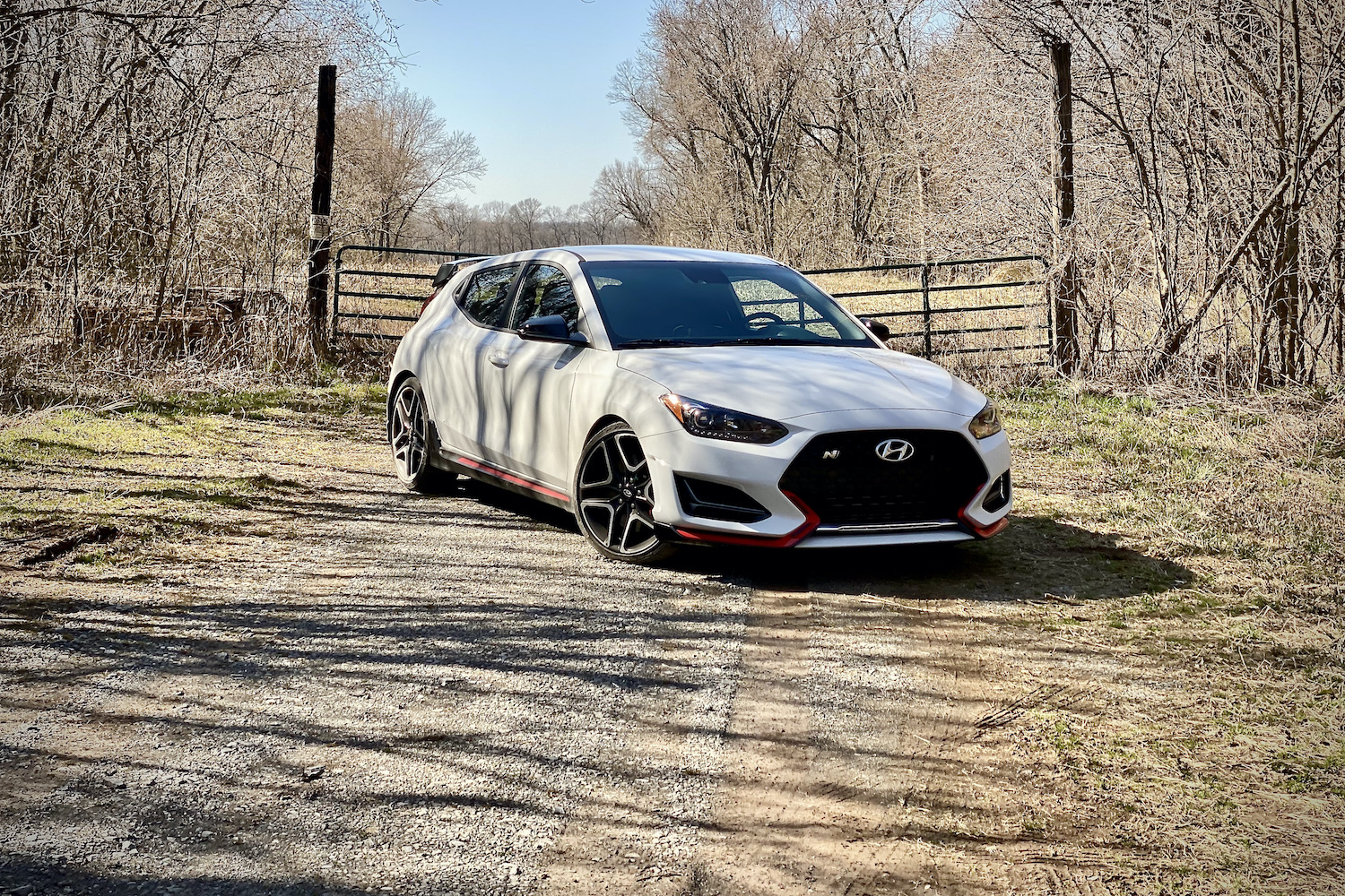 Hyundai Veloster N front end from passenger side in front of a fence.