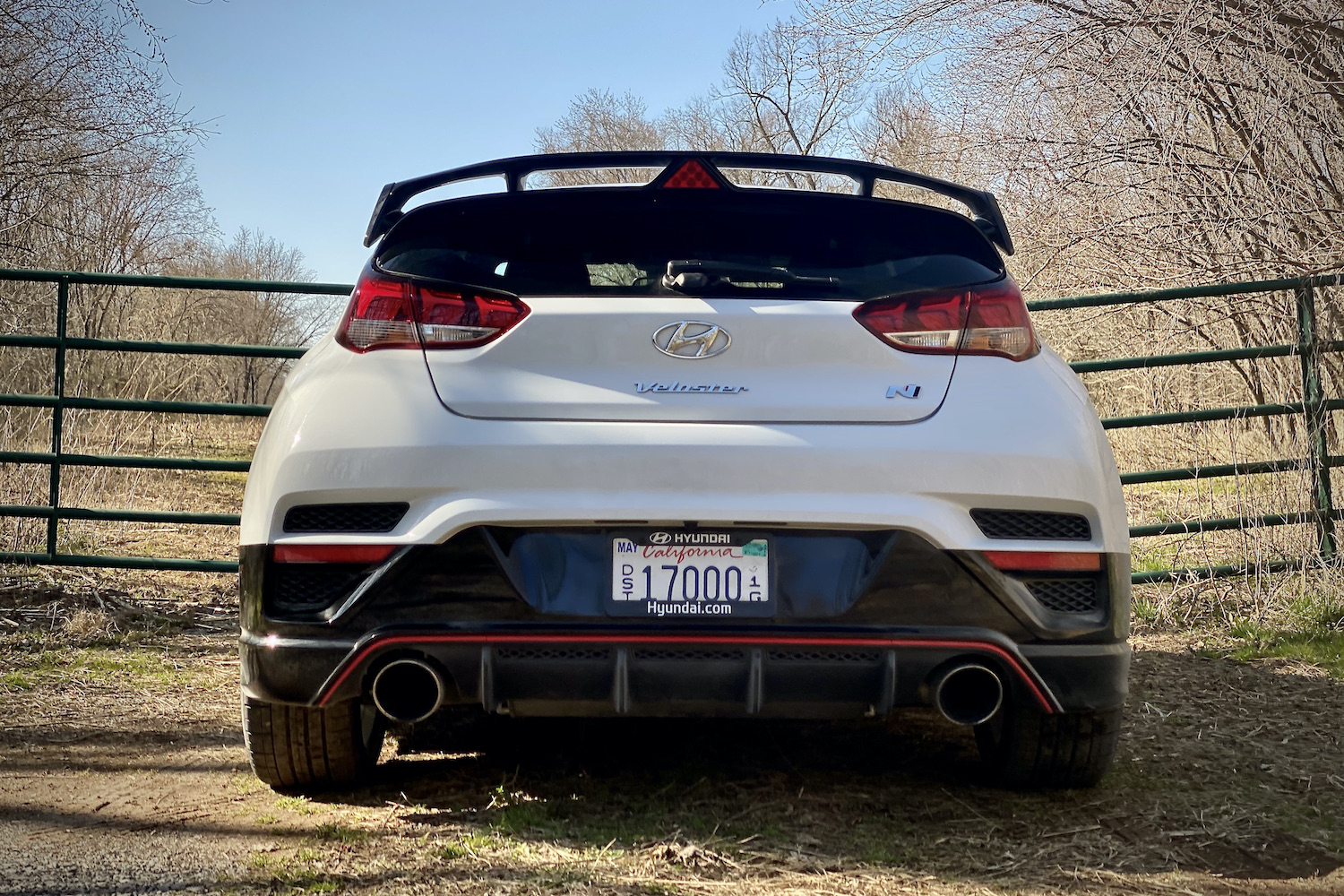 Hyundai Veloster N rear end close up with a fence in the back.