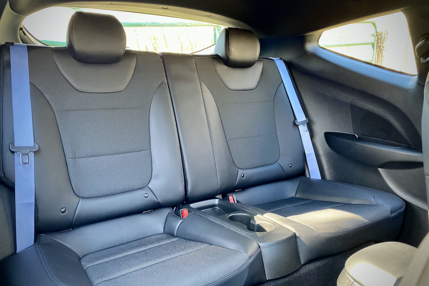 Hyundai Veloster N rear seats close up with blue seat belts.