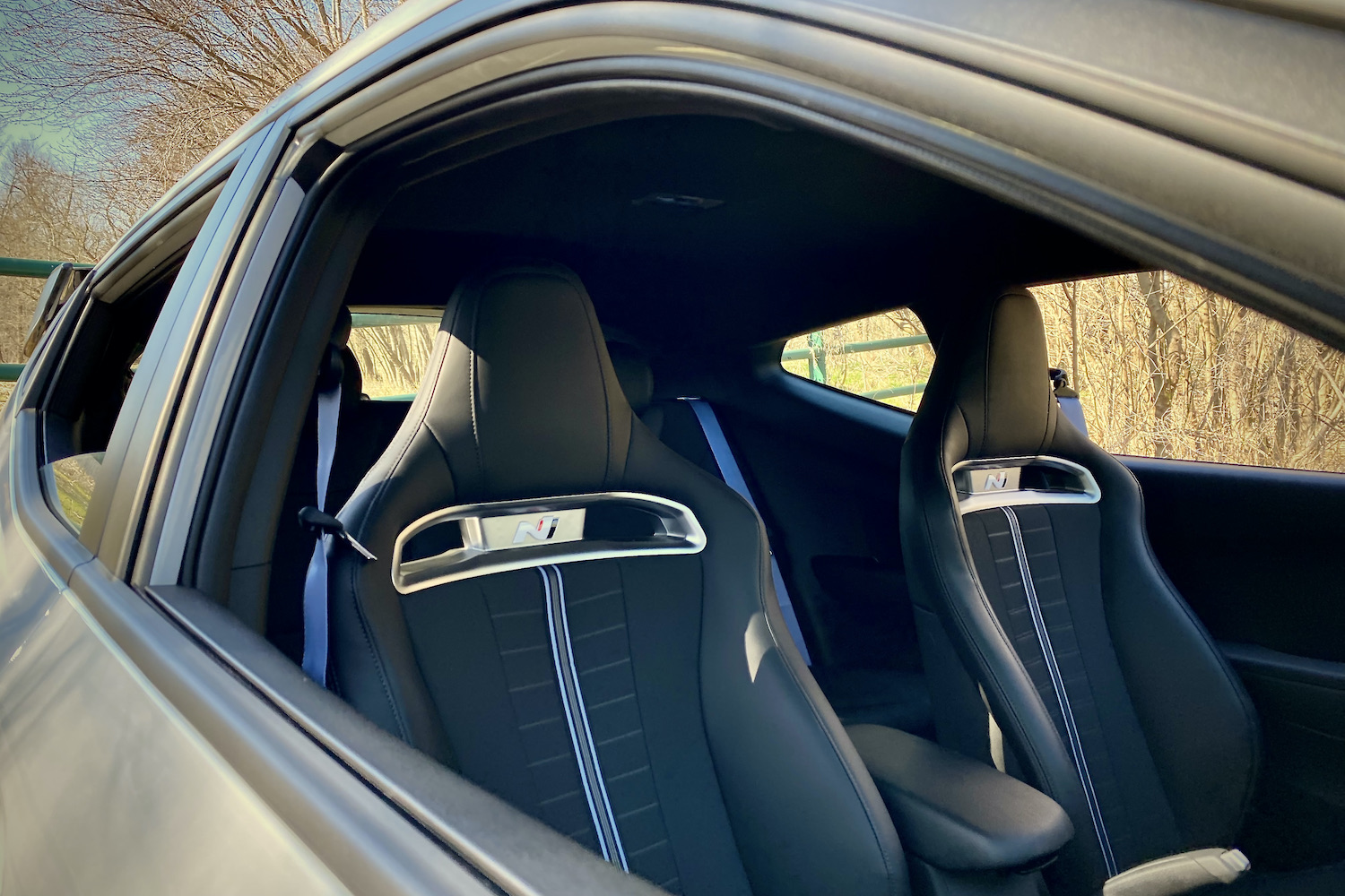 Hyundai Veloster N passenger seat close up with trees in the background.