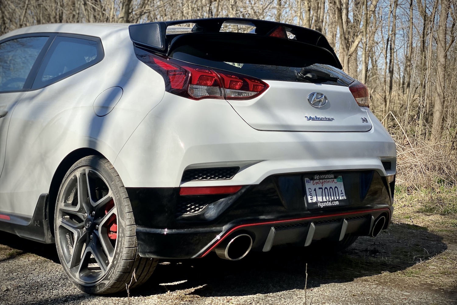 Hyundai Veloster N rear end close up from driver side with trees in the background.