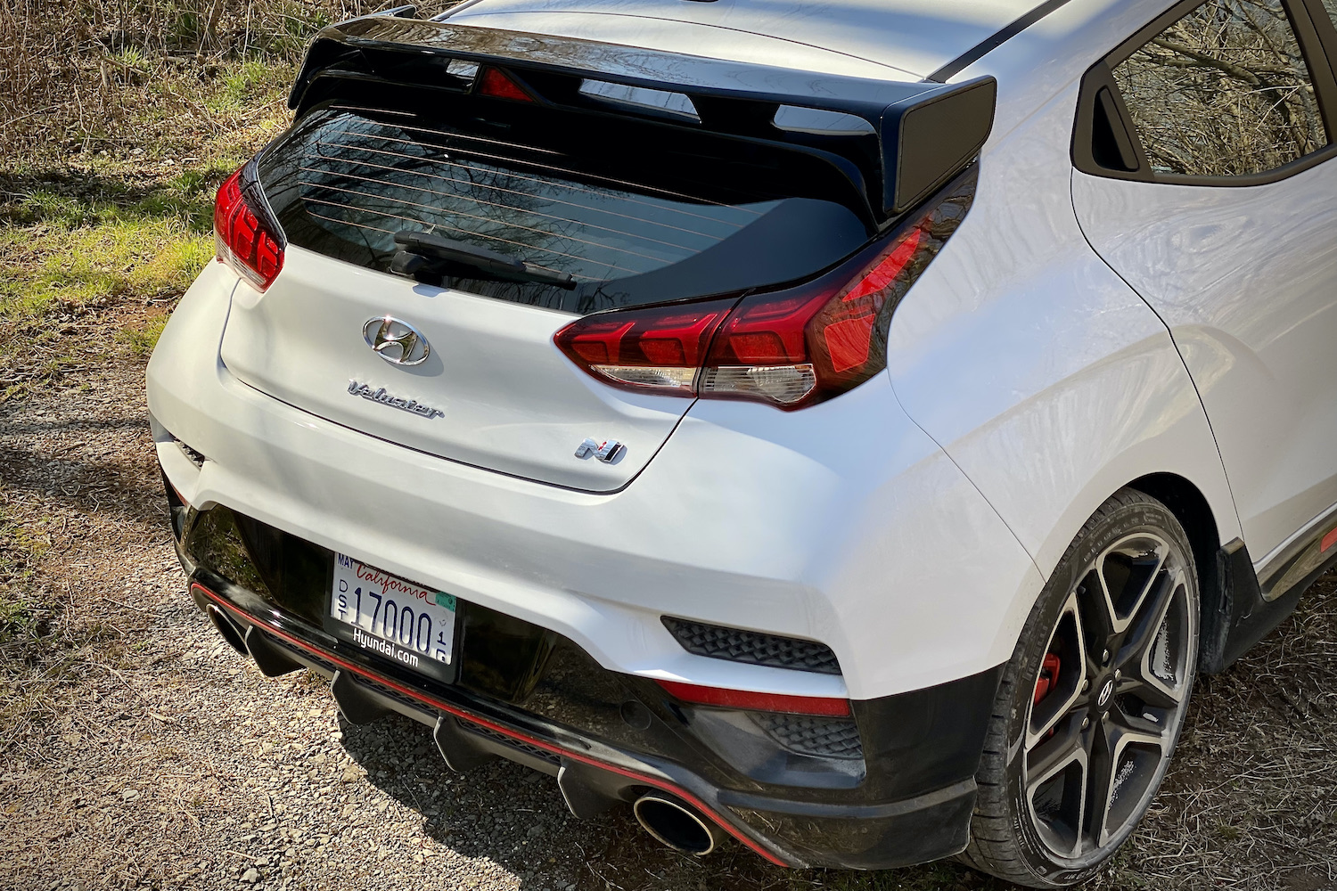 Hyundai Veloster N close up of rear end from passenger side on a dirt road.