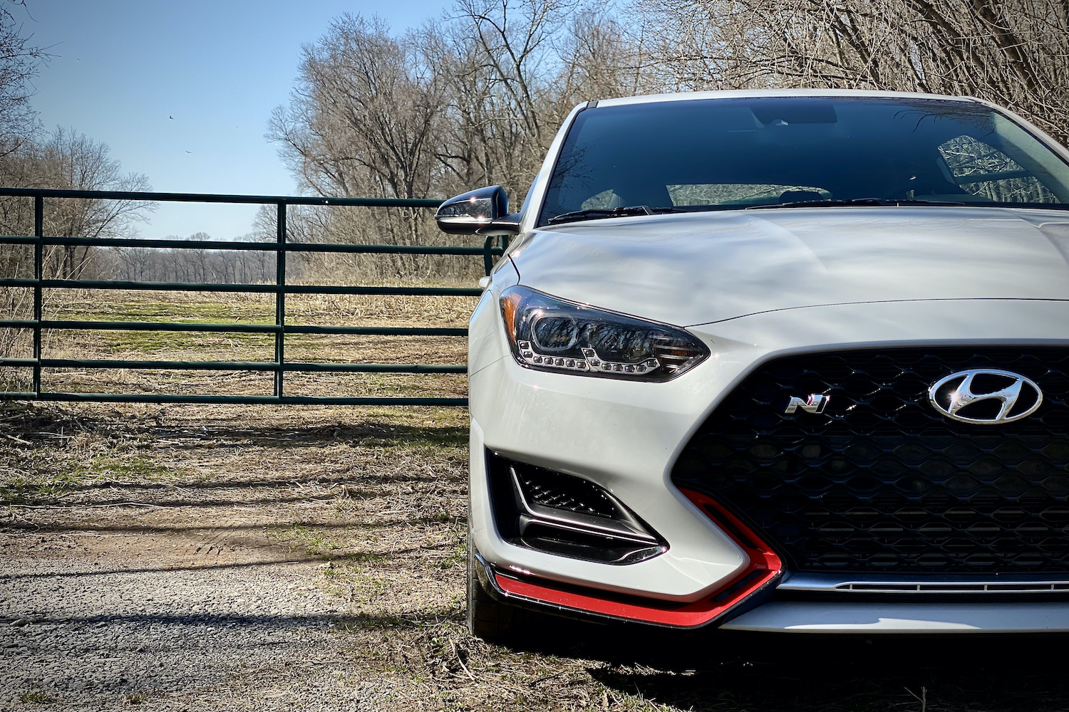 Hyundai Veloster N close up of left side of front end in front of a fence.