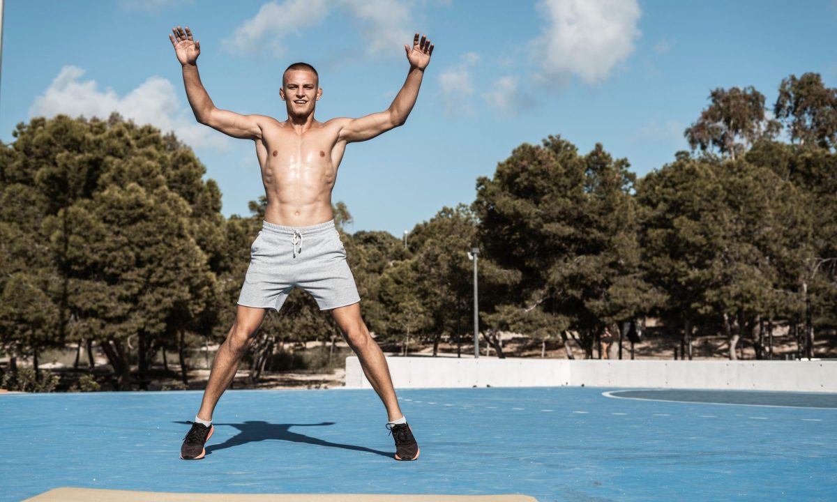 Shirtless man doing jumping jacks