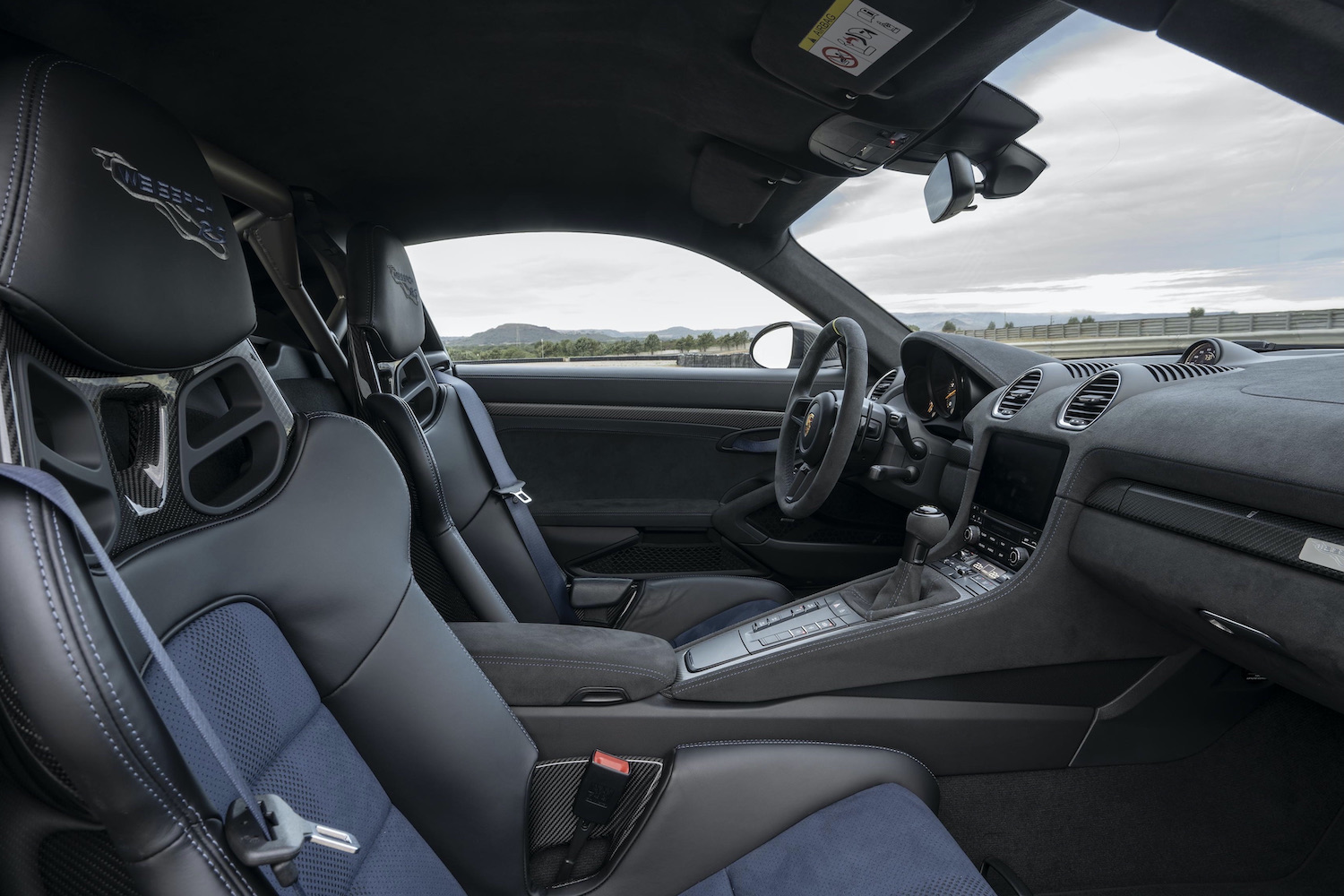 Porsche 718 Cayman GT4 RS interior close up of passenger seat at sunset.