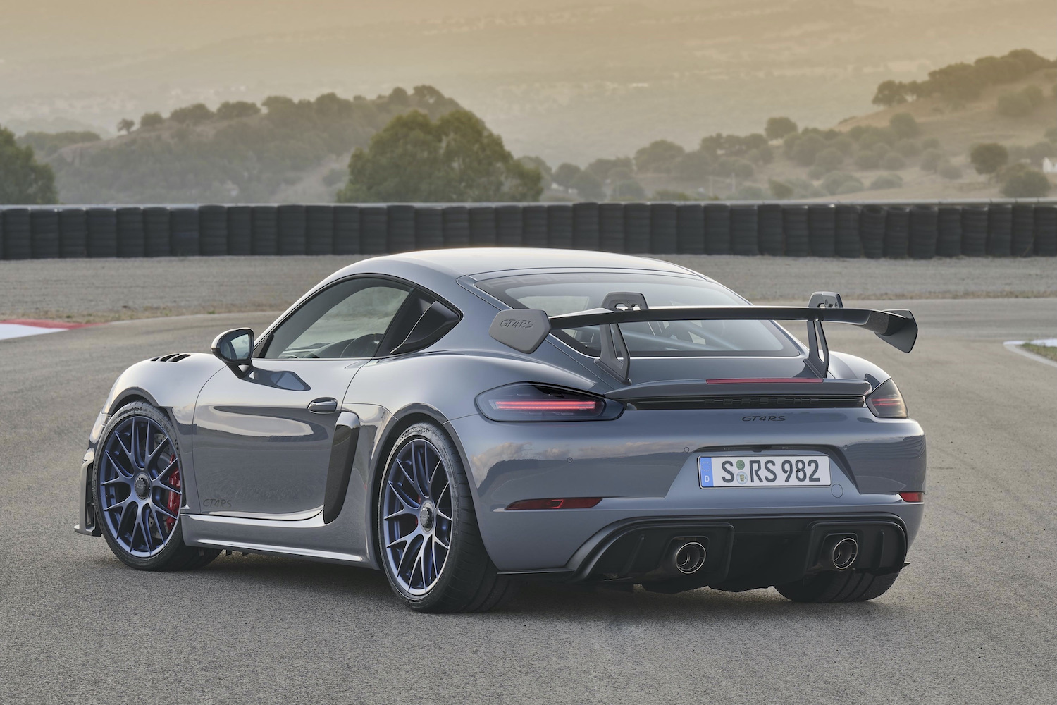 Porsche 718 Cayman GT4 RS rear end angle from the driver's side on track.