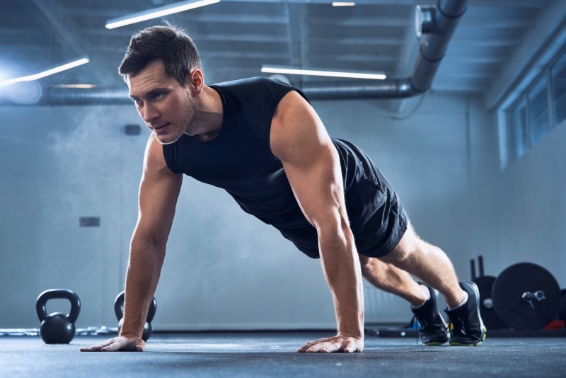 Man doing push-ups at a gym.