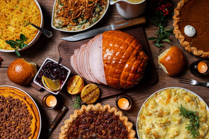 Thanksgiving meal with turkey breast, pies and casseroles on a table.