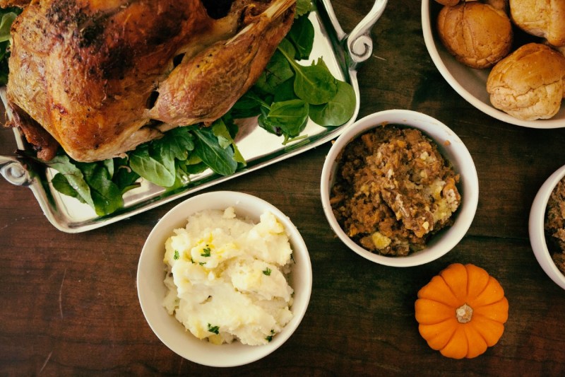thanksgiving side dishes sitting next to a roasted turkey on a platter.
