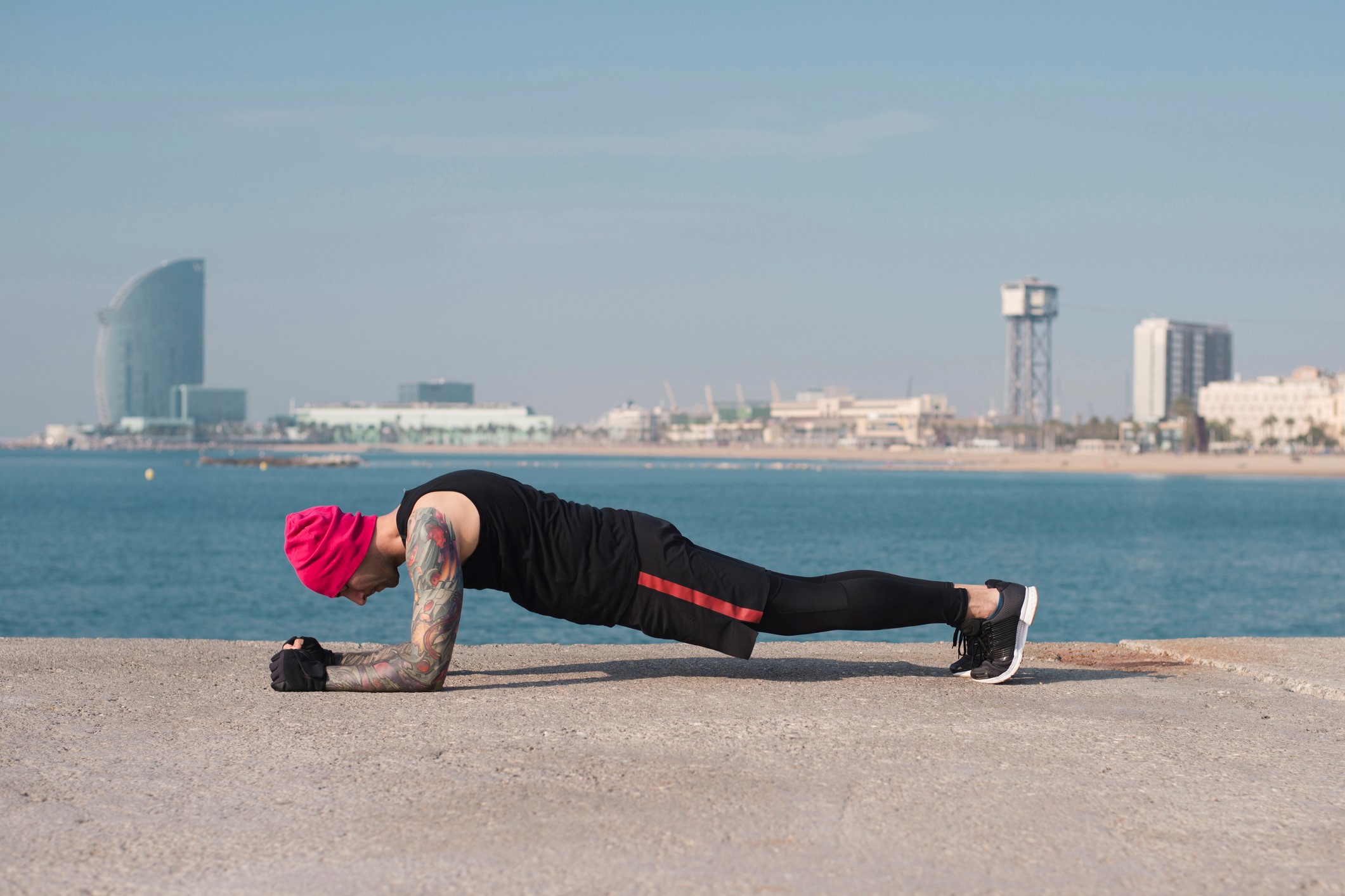 Side view of man doing boards from top to bottom on the beach.