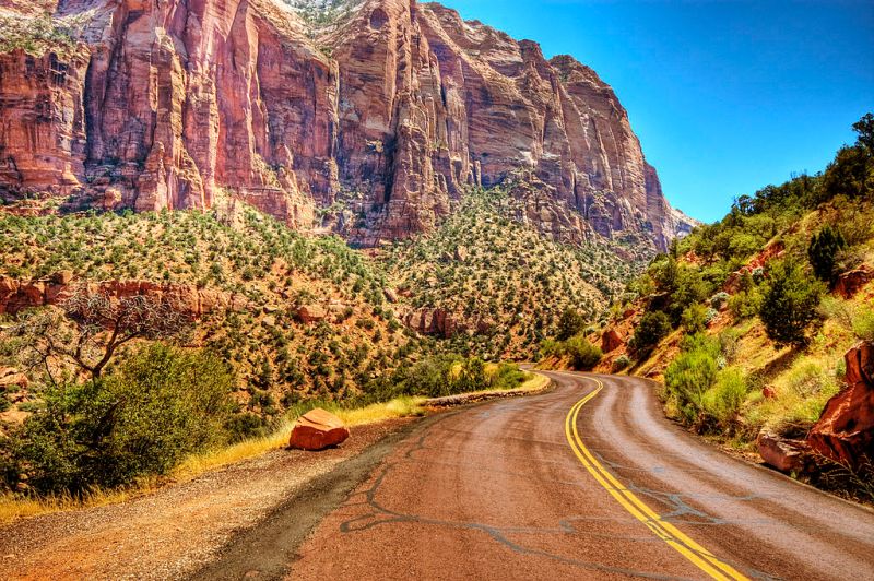 windy road going through the mountainous Zion National Park.